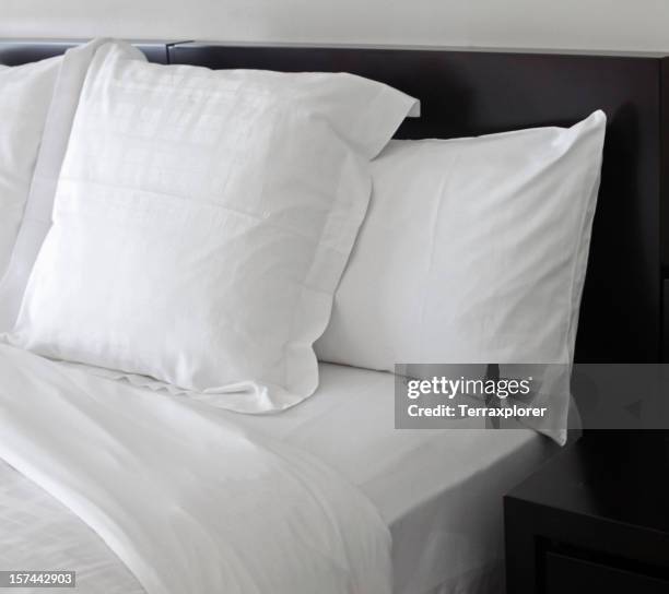 bed with white pillows - bed pillows stock pictures, royalty-free photos & images