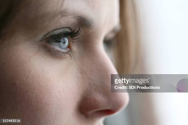 closeup of young woman gazing away - female profile stock pictures, royalty-free photos & images