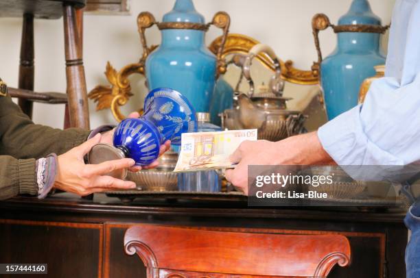 shopping in einem antiquitätengeschäft - antiquität stock-fotos und bilder