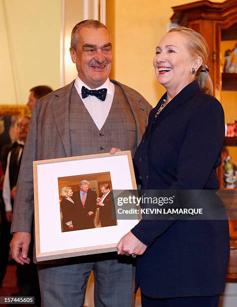 Secretary of State Hillary Clinton and Czech Foreign Minister Karel Schwarzenberg pose with a file photo showing her and her husband, former US...