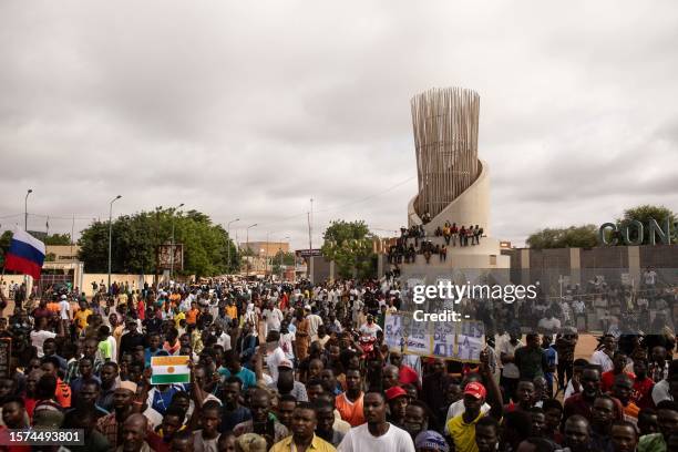 Protesters hold placards denouncing Economic Community of West African States during a demonstration on independence day in Niamey on August 3, 2023....