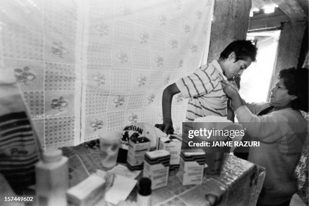 In this picture from July 1996 Mario, an HIV positive person, is helped by his mother to fit his t-shirt before leaving for a drive. Mario died on...