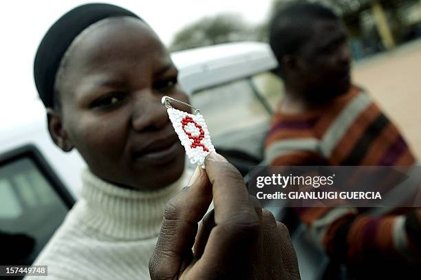 Dineo Sumoke, member of the HIV+ support group in Gabane holds, 26 September 2007, the red ribbon as awareness symbol against HIV/AIDS in the...