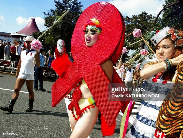 File photo taken 08 September 2002 shows a Japanese woman displaying an anti-AIDS costume as she marches along with others at the Tokyo Lesbian and...