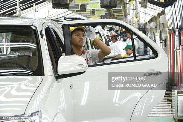 Indonesian workers inspect Toyota vehicles at the assembly line of Toyota Motor's Indonesian unit, Toyota Motor Manufacturing Indonesia plant in...