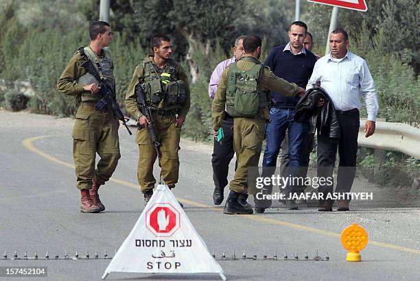 Israeli soldiers prevent a man from going to see the body of his brother, Hatem Shadid, who was shot dead earlier by Israeli forces from the Shin Bet...