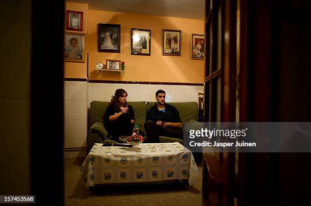 Unemployed twenty-year old Maria Regina Fernandez spends the night watching television with her boyfriend, who does also not hold a job, instead of...