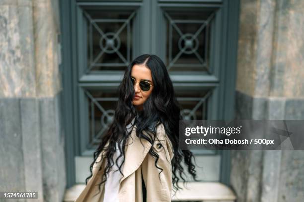 portrait of young woman wearing sunglasses while standing against building,spain - designer sunglasses stock pictures, royalty-free photos & images