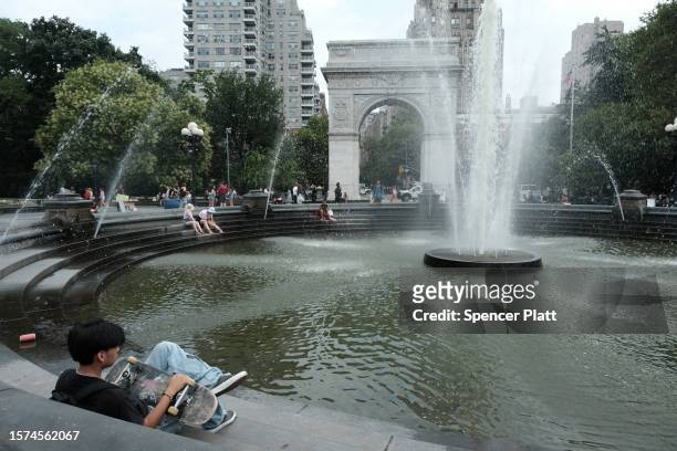 People try to keep cool by the fountain in Washington Square Park during a heat wave on July 27, 2023 in New York City. New York City and much of the...