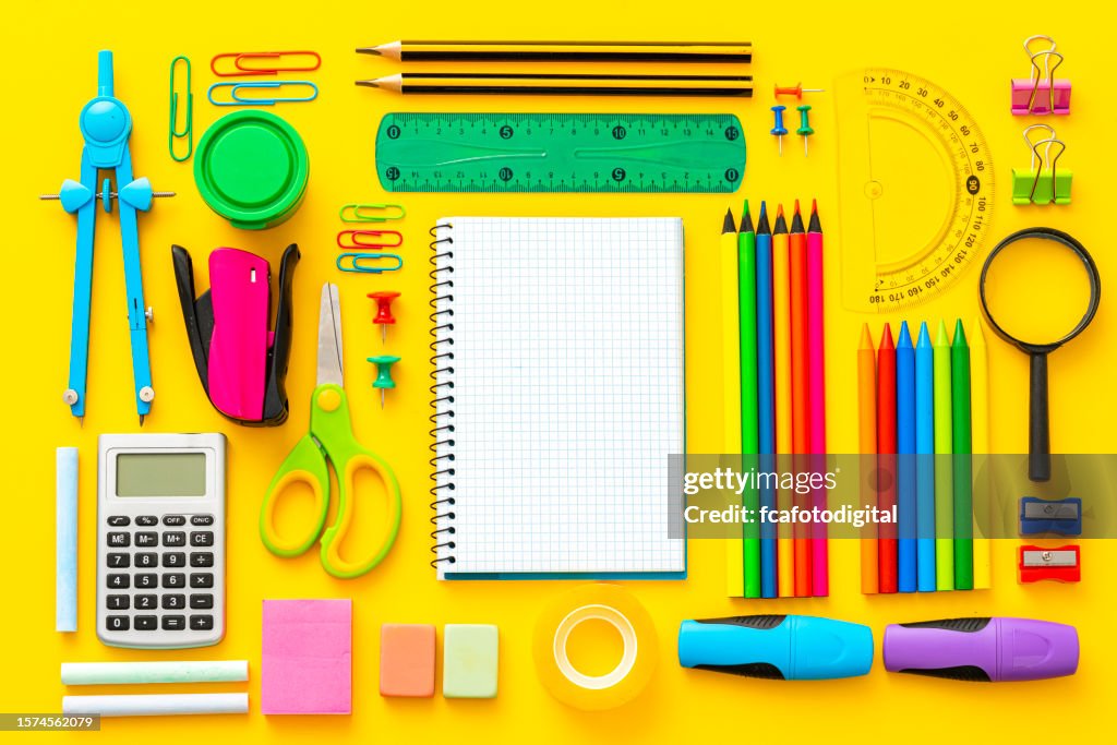 Multi colored school supplies shot on yellow background
