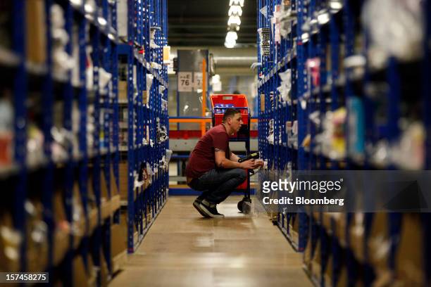 An employee selects goods from storage units ahead of packaging for delivery at the Amazon.co.uk Marston Gate 'Fulfillment Center,' the U.K. Site of...