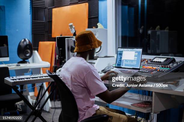 young man working late in recording studio,accra,ghana - geluidsoverlast stockfoto's en -beelden