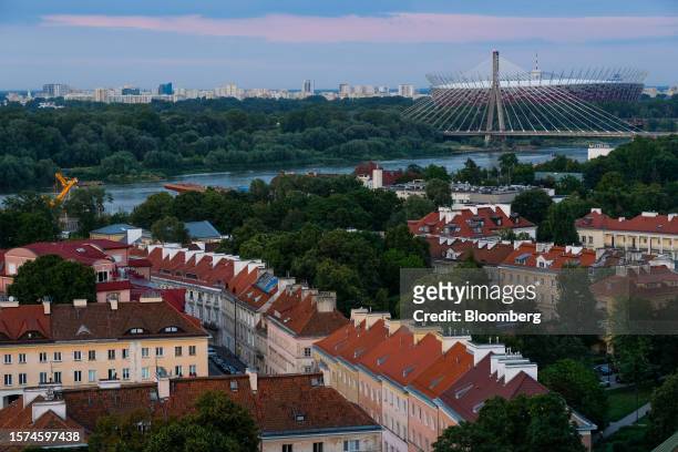 Tenement houses in front of the Vistula River, the Swietokrzyski Bridge, and the PGE National Stadium, in the old town area of Warsaw, Poland, on...