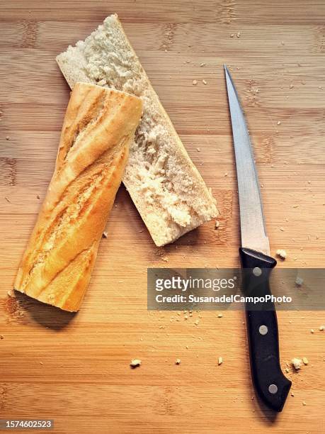overhead view of a halved baguette and a knife on a table - half photos et images de collection