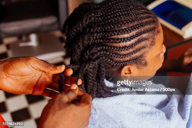young barber spends time working on clients hair,salon work,tema,ghana - zwart haar stockfoto's en -beelden