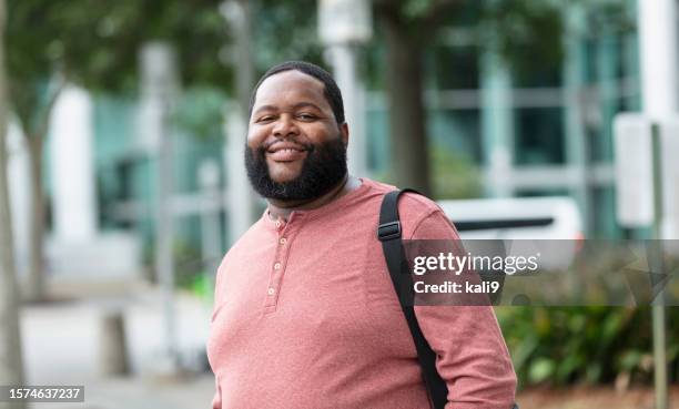 african-american man with beard walking in city - heavy stock pictures, royalty-free photos & images