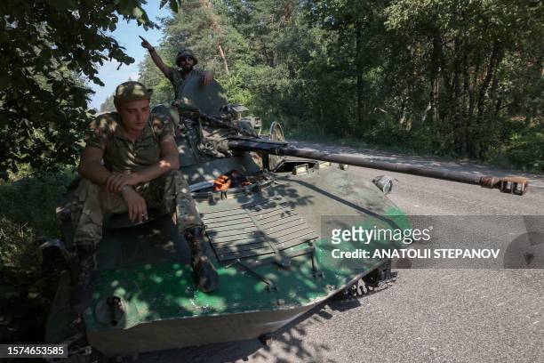 Ukrainian servicemen rest on their airborne infantry fighting vehicle on the road in Donetsk region on August 3, 2023.