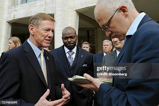 Alan Mulally, president and chief executive officer of Ford Motor Co., left, speaks to the media as former professional football player Emmitt Smith,...