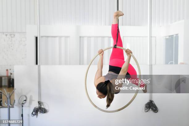 woman doing acrobacy in a lyra hoop - aerial hoop stock pictures, royalty-free photos & images