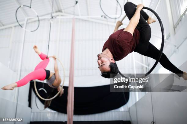 people doing aerial gymnastics with a lyra hoop - lyra stock pictures, royalty-free photos & images
