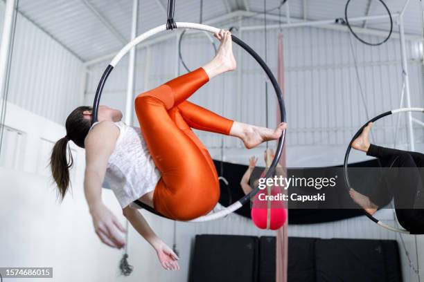people sitting in a lyra hoop doing aerial gymnastics - lyra stock pictures, royalty-free photos & images