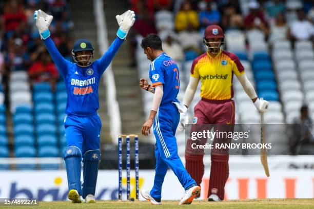 Yuzvendra Chahal and Ishan Kishan of India celebrate the dismissal of Brandon King of West Indies during the first T20I match between West Indies and...