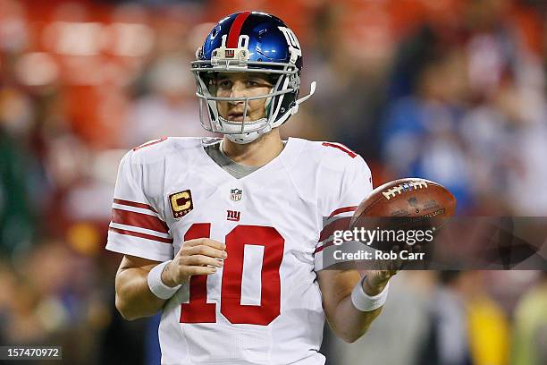 Quarterback Eli Manning of the New York Giants waits to throw a pass while warming up before the start of the Giants game against the Washington...