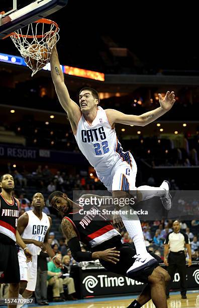 Byron Mullens of the Charlotte Bobcats dunks on LaMarcus Aldridge of the Portland Trail Blazers during their game at Time Warner Cable Arena on...