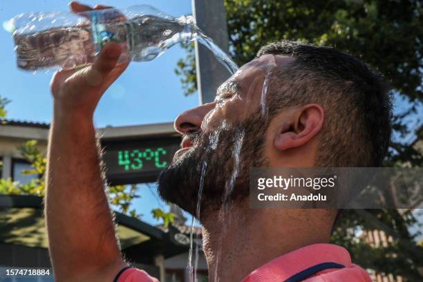 Man pours water on his head to cool off as the temperature hits 44 degrees Celsius in Bursa, Turkiye on August 03, 2023.