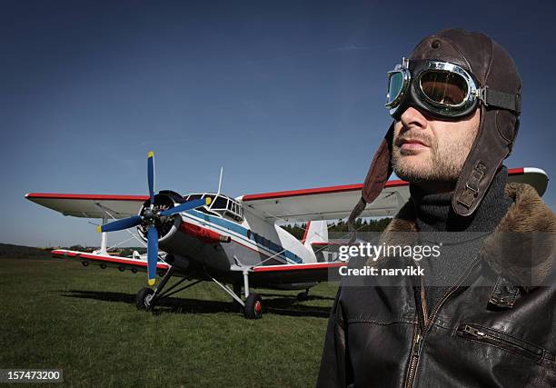 pilot mit dem flugzeug - fliegermütze stock-fotos und bilder