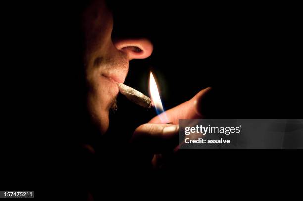 smoking a joint - human joint stockfoto's en -beelden