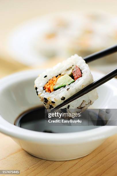dipping california roll sushi - soy sauce stock pictures, royalty-free photos & images