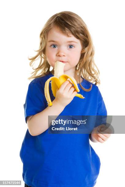 kleines mädchen essen banane - kind ca 3 jahre freigestellt stock-fotos und bilder