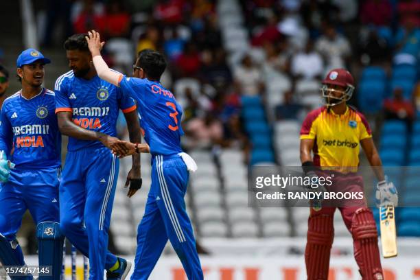 Ishan Kishan , Hardik Pandya and Yuzvendra Chahal of India celebrate the dismissal of Nicholas Pooran of West Indies during the first T20I match...
