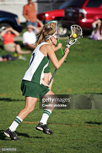 female lacrosse player in green and white runs with ball - lacrosse 個照片及圖片檔
