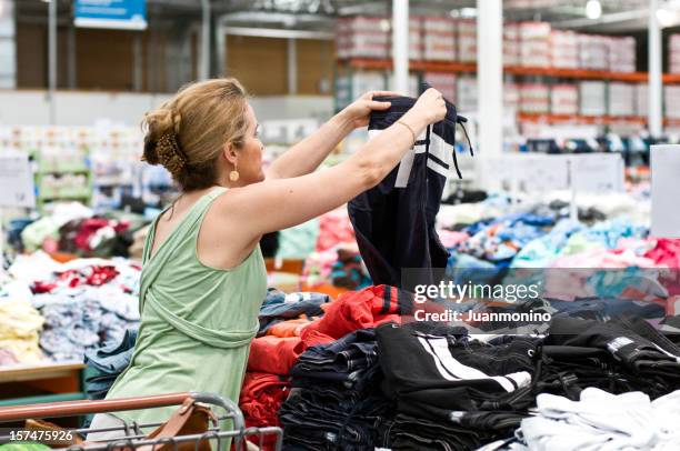 mulher para comprar roupas em uma loja tipo de comércio. - loja de descontos - fotografias e filmes do acervo