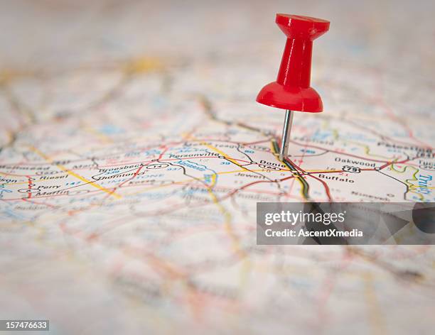 close-up of a push pin stuck in a map - punaise stockfoto's en -beelden