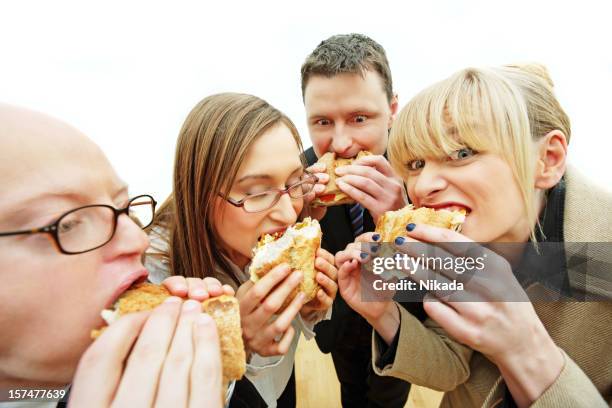 affamato ufficio lavoratori - mezzogiorno foto e immagini stock