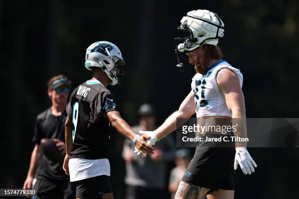 Bryce Young and Hayden Hurst of the Carolina Panthers react during Carolina Panthers Training Camp at Wofford College on July 27, 2023 in...