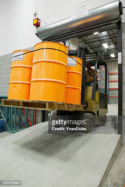 forklift in warehouse carrying yellow barrel - toxic waste stock pictures, royalty-free photos & images