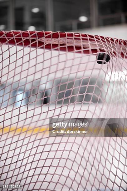 hockey puck aufnahme in das net - eishockey tor stock-fotos und bilder