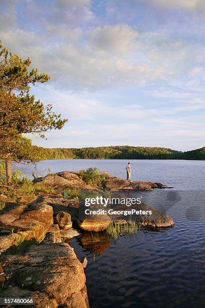 young man enjoying serene moment on wilderness lake - boundary waters canoe area stock pictures, royalty-free photos & images