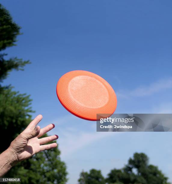 disco volador y una mano - frisbee fotografías e imágenes de stock