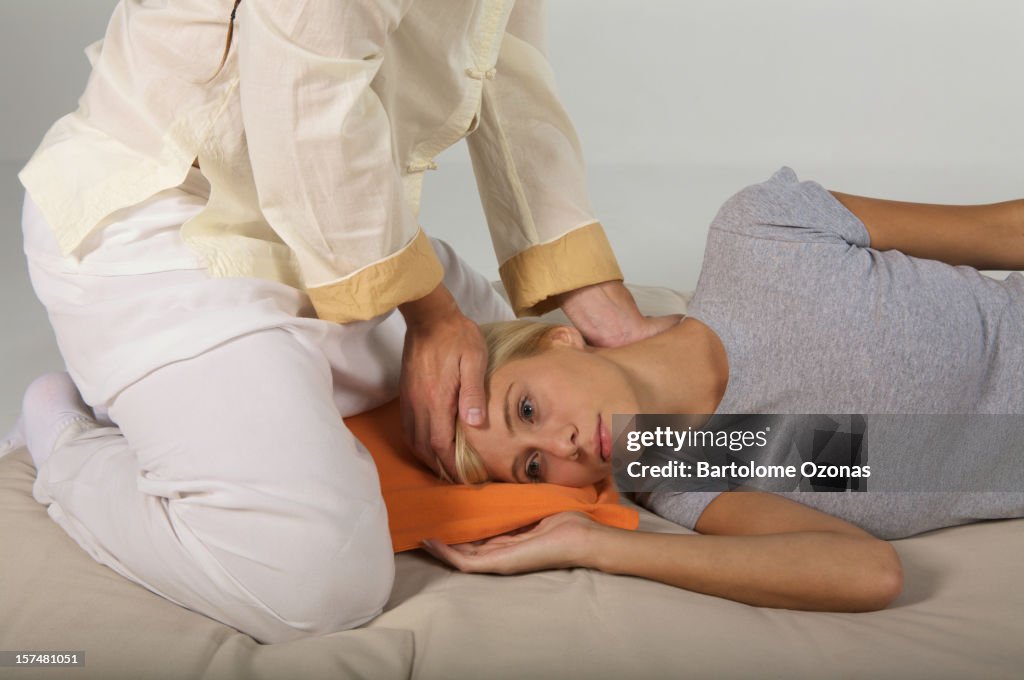 Zen Shiatsu therapist applying massage on a woman