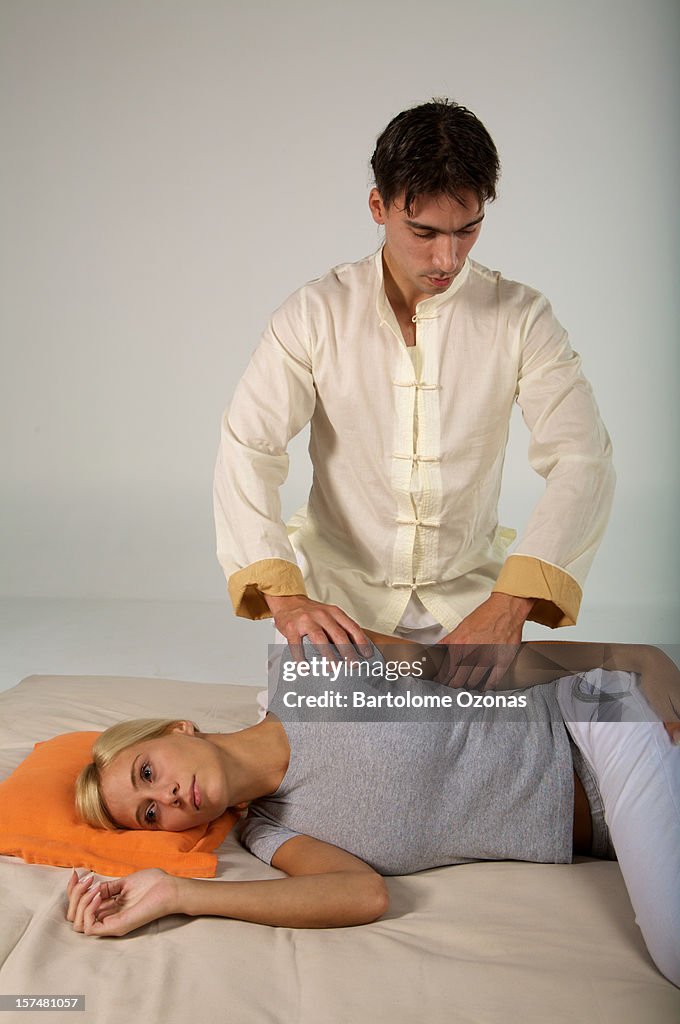 Zen Shiatsu therapist applying massage on a woman