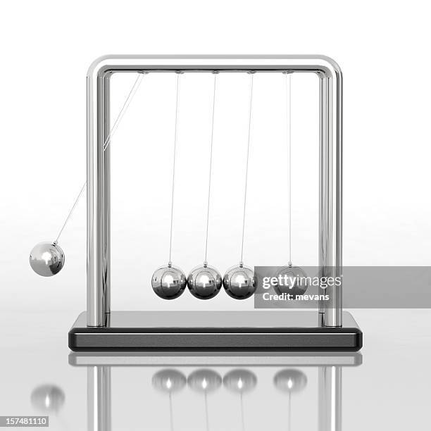 newton's cradle sitting on a reflective desk - newtons cradle stock pictures, royalty-free photos & images