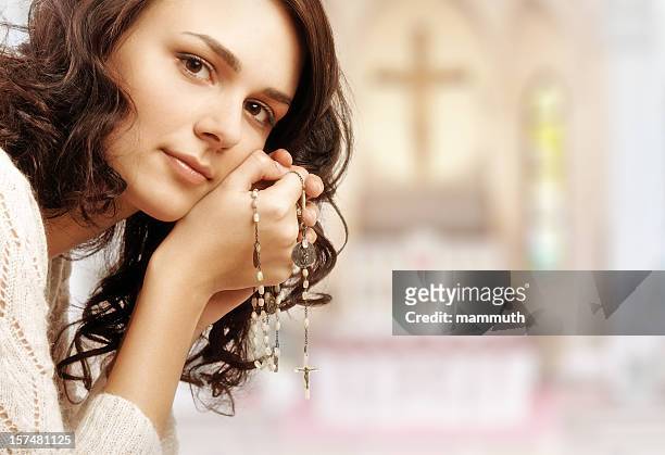 praying girl in the temple - rosary beads stock pictures, royalty-free photos & images