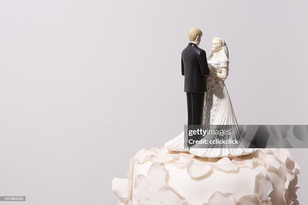 Bride and groom decorations on top of a wedding cake