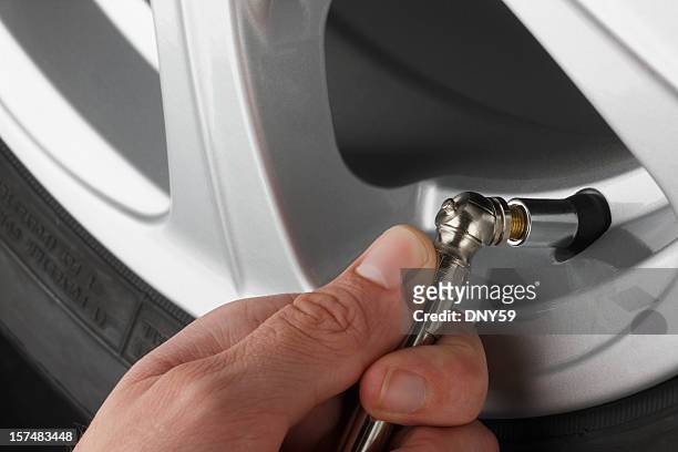 control de presión de aire en un automóvil de neumáticos - inflar fotografías e imágenes de stock