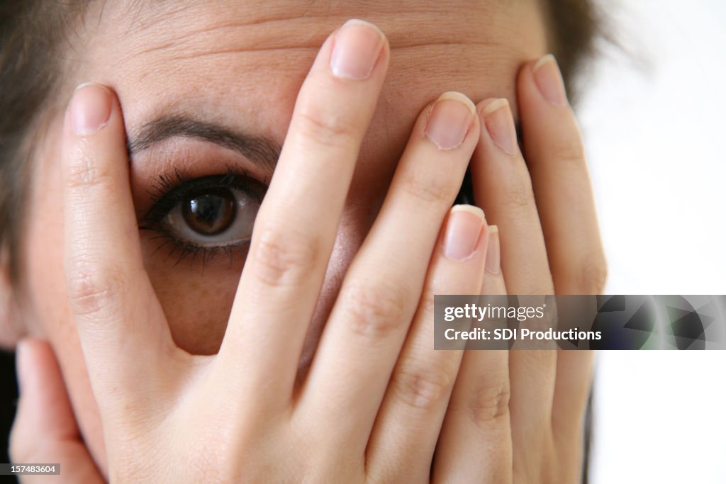 Young Woman Peeking Through Her Fingers